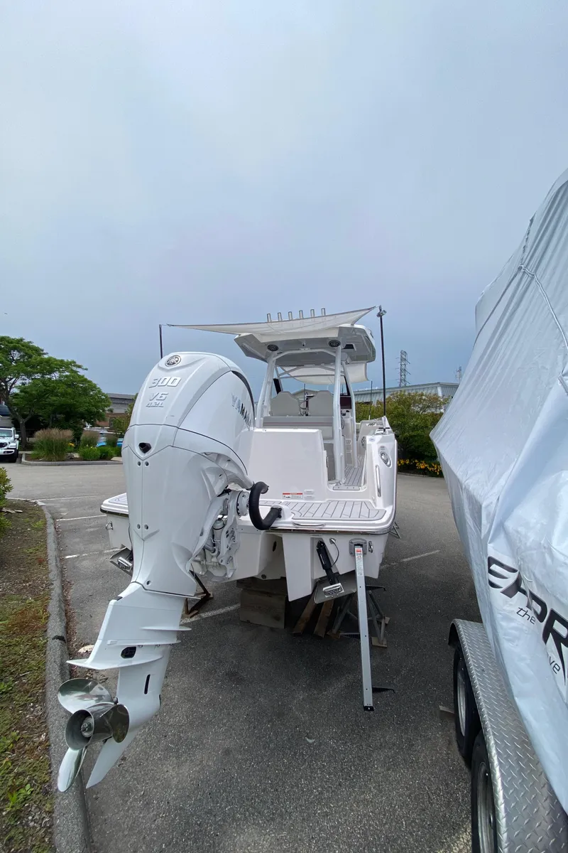 Slide: The Image of 2025 Solara S-250 CW boat with powerful outboard motor in a parking area. - 5