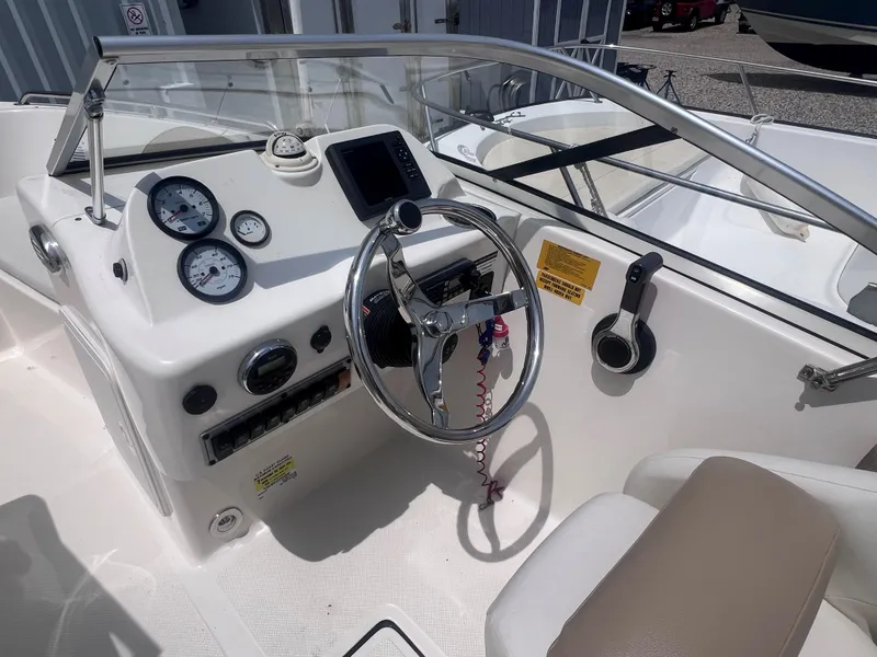Slide: The Image of 2016 Key West 186 Dual Console boat dashboard with steering wheel and gauges. - 12