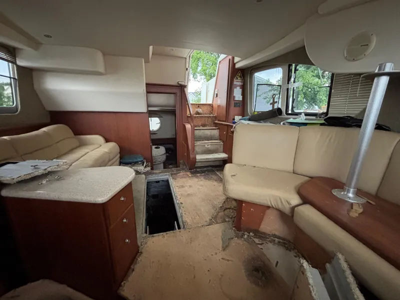 Slide: The Image of Interior of a 2004 Silverton 35 Motor Yacht with beige seating and wooden accents. - 14