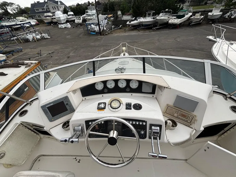Slide: The Image of 2004 Silverton 35 Motor Yacht helm with gauges, controls, and navigation equipment in a marina setting. - 5