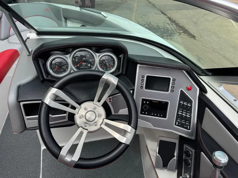 Slide: The Image of 2018 MasterCraft XT23 boat dashboard with steering wheel and control panel. - 10