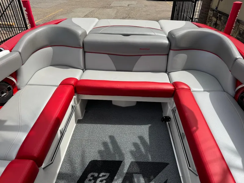 Slide: The Image of 2018 MasterCraft XT23 boat interior with red and gray seating. - 13