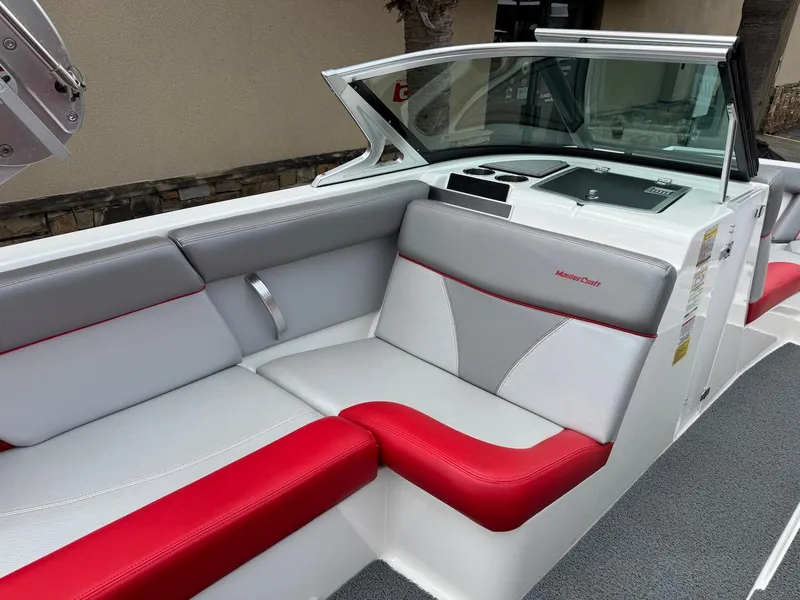 Slide: The Image of 2018 MasterCraft XT23 boat interior with red and gray seating, modern design. - 8