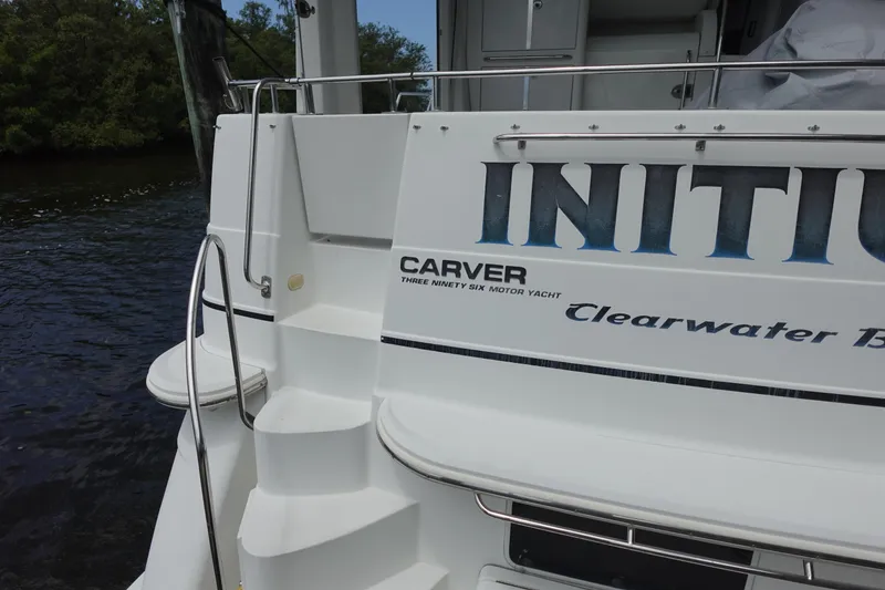Slide: The Image of 2004 Carver 396 Aft Cabin Motor Yacht docked, featuring rear steps and branding. - 13