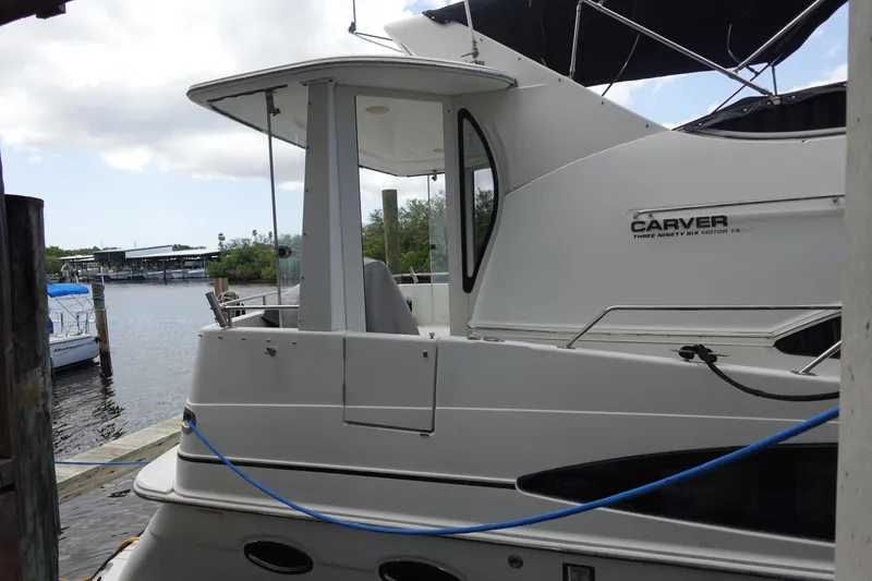Slide: The Image of 2004 Carver 396 Aft Cabin Motor Yacht docked by the water. - 17