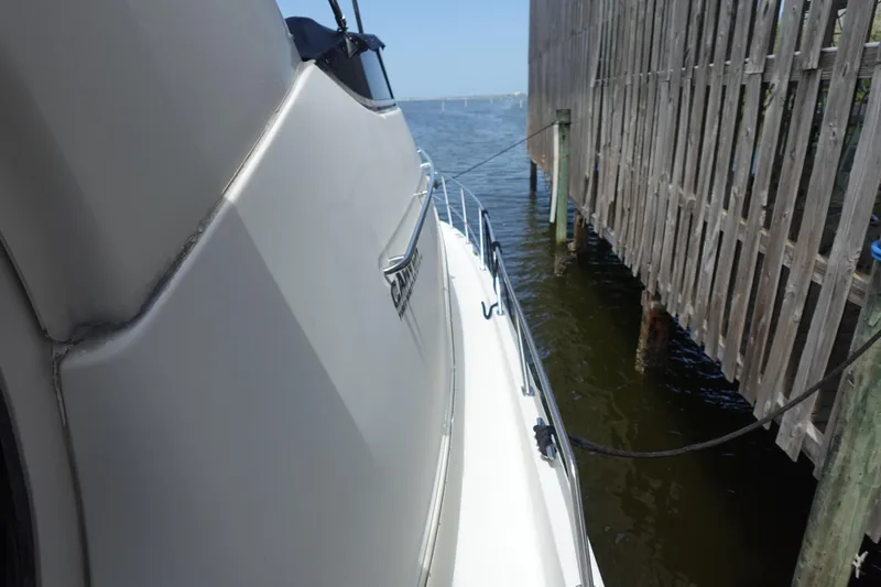 Slide: The Image of 2004 Carver 396 Aft Cabin MY docked beside wooden structure on water. - 19