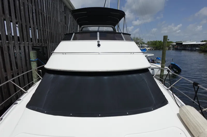 Slide: The Image of 2004 Carver 396 Aft Cabin MY yacht docked by wooden pier under blue sky. - 21