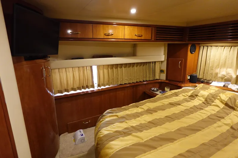 Slide: The Image of Luxurious 2004 Carver 396 Aft Cabin MY bedroom with wood cabinetry and striped bedding. - 26