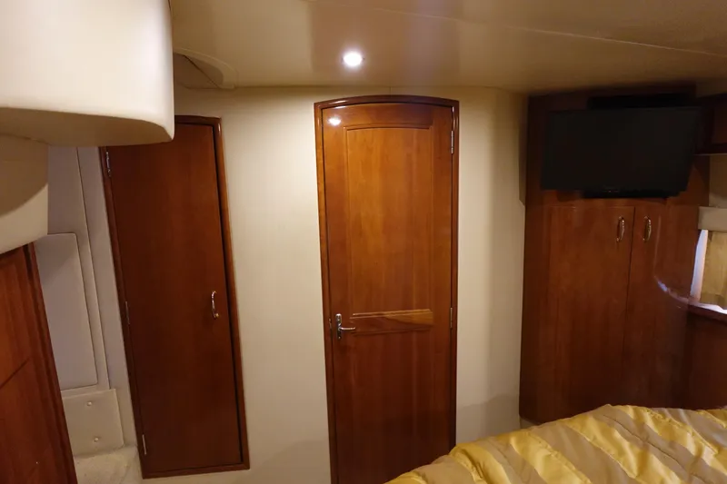 Slide: The Image of 2004 Carver 396 Aft Cabin MY interior with wooden doors and mounted TV. - 28