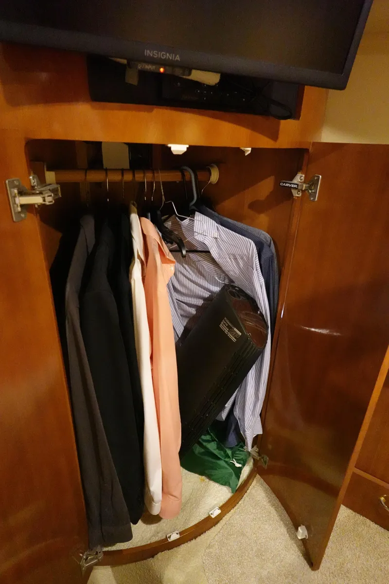 Slide: The Image of Clothes hanging in a wooden closet inside a 2004 Carver 396 Aft Cabin MY. - 32