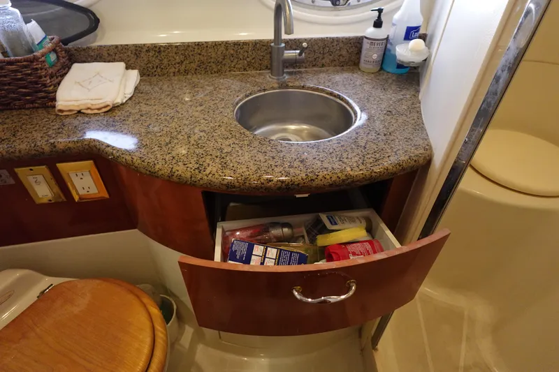 Slide: The Image of 2004 Carver 396 Aft Cabin MY bathroom with granite countertop and open storage drawer. - 34