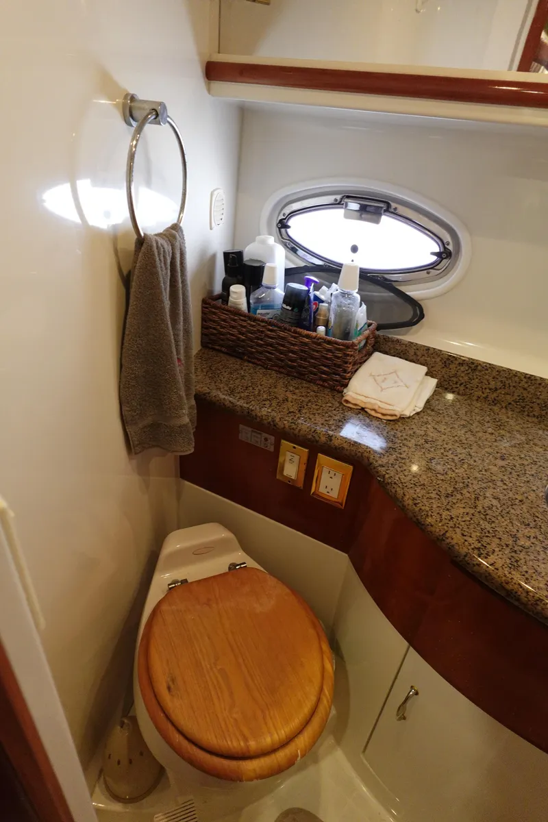 Slide: The Image of 2004 Carver 396 Aft Cabin MY bathroom with granite countertop and wooden toilet seat. - 38
