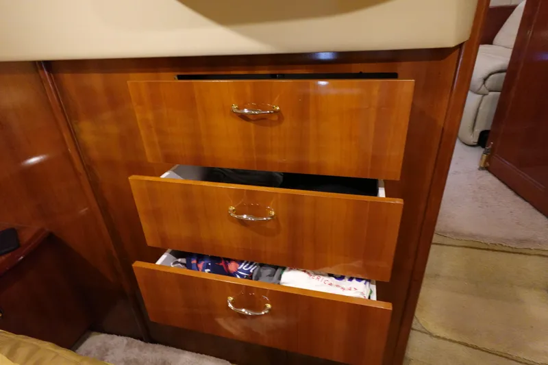 Slide: The Image of Wooden drawers in a 2004 Carver 396 Aft Cabin MY, partially open with clothes inside. - 43