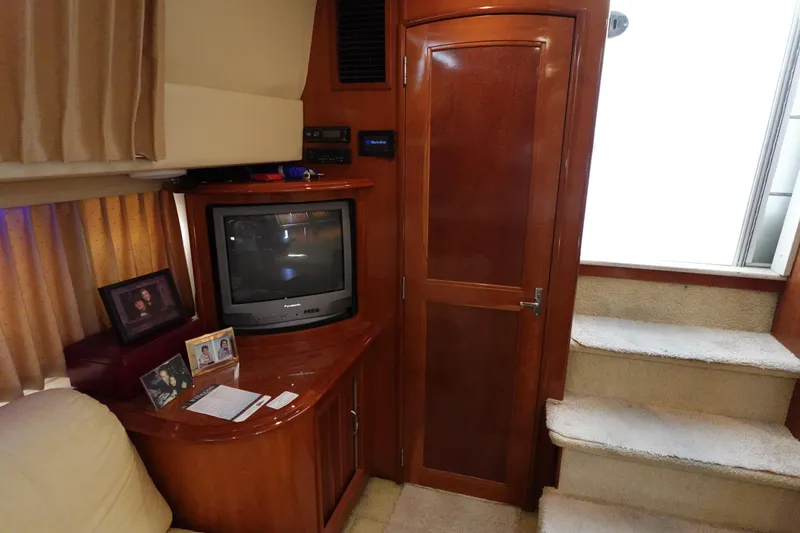 Slide: The Image of Interior of 2004 Carver 396 Aft Cabin MY with TV, wooden cabinetry, and carpeted stairs. - 48