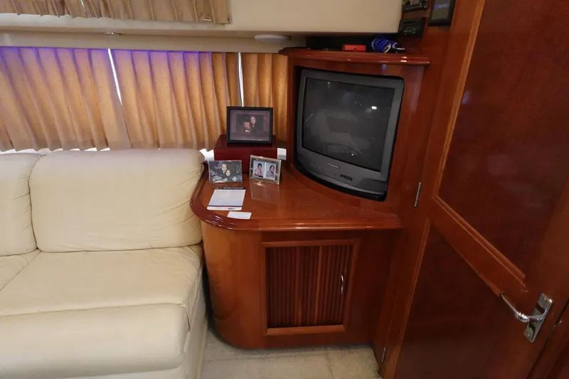 Slide: The Image of Interior of 2004 Carver 396 Aft Cabin MY with TV, sofa, and framed photos. - 49