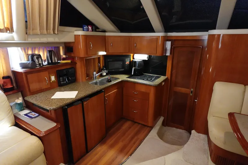 Slide: The Image of 2004 Carver 396 Aft Cabin MY yacht interior kitchen with wood cabinetry and modern appliances. - 9