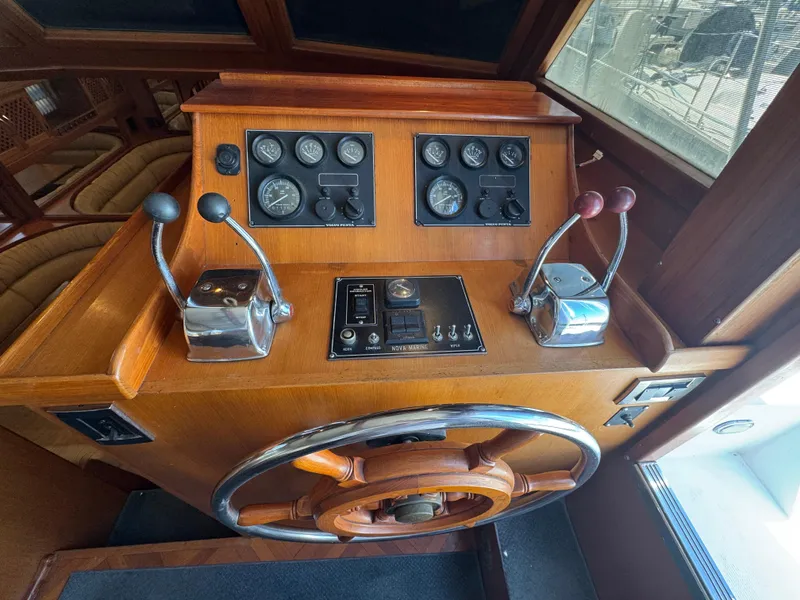 Slide: The Image of Control panel of a 1990 Nova 48 boat with gauges and steering wheel. - 13