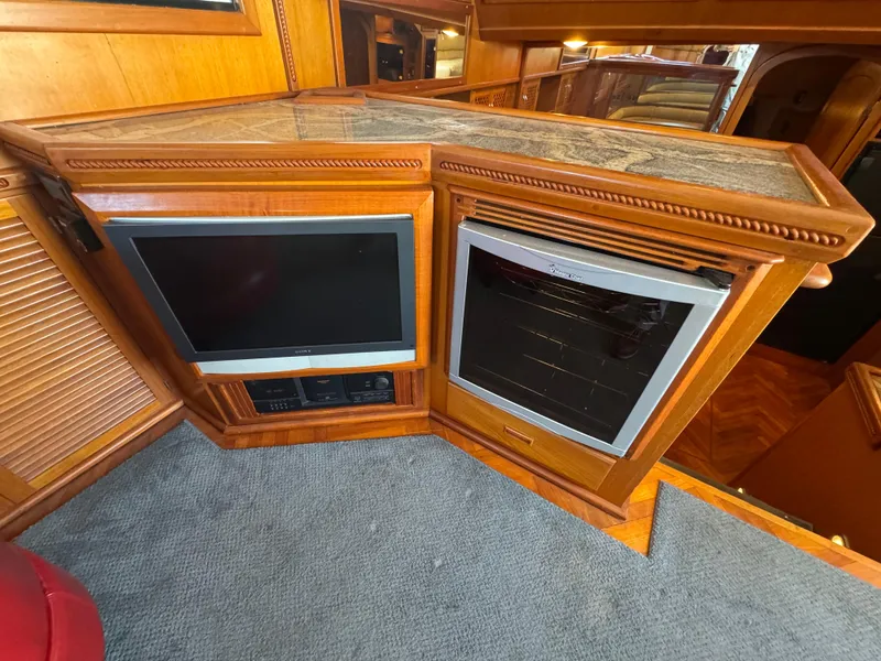 Slide: The Image of Wooden interior of a 1990 Nova 48 yacht with TV and mini-fridge. - 14