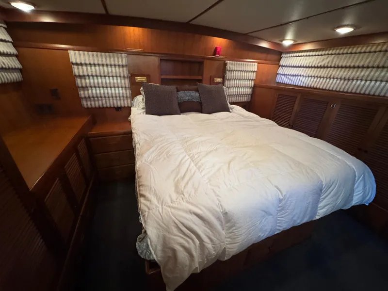 Slide: The Image of Cozy bedroom in a 1990 Nova 48 yacht with wood paneling and soft lighting. - 15