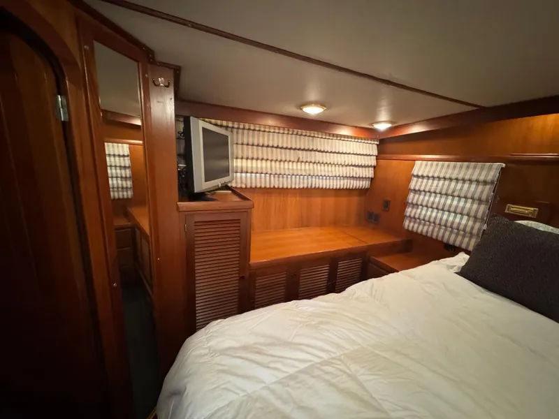 Slide: The Image of Cozy cabin interior of 1990 Nova 48 yacht with wood paneling and striped curtains. - 16