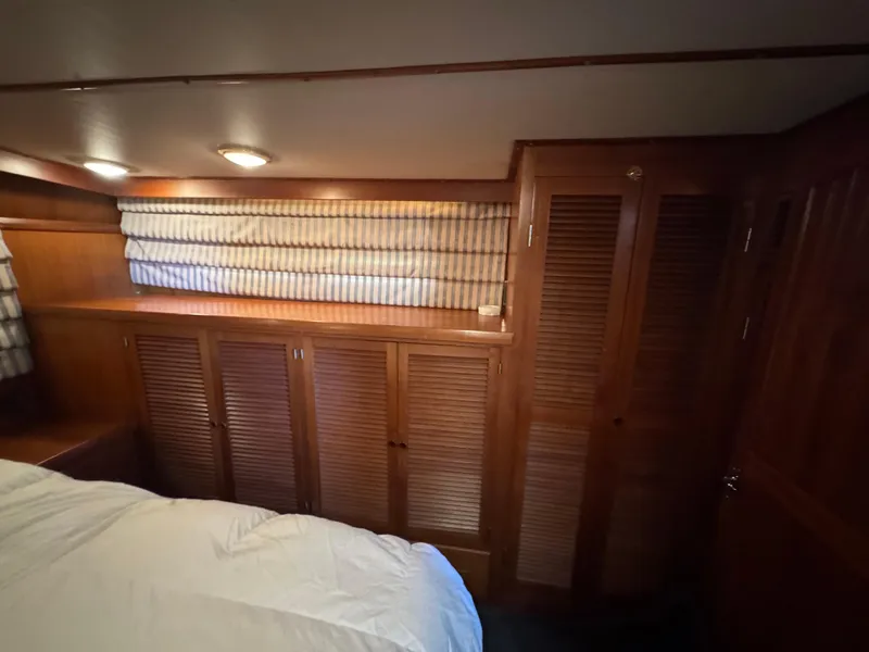 Slide: The Image of Cozy wooden interior of 1990 Nova 48 yacht cabin with striped curtains and storage cabinets. - 18