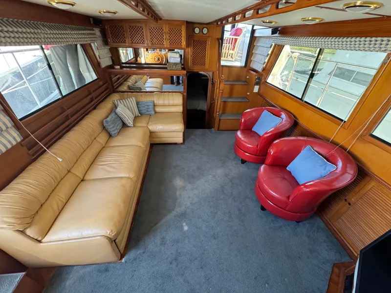 Slide: The Image of Luxurious 1990 Nova 48 yacht interior with beige sofa, red chairs, and nautical decor. - 21