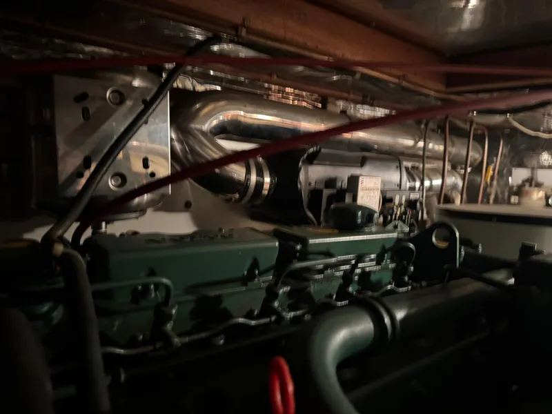 Slide: The Image of Engine compartment of a 1990 Nova 48, showcasing mechanical components and wiring. - 26