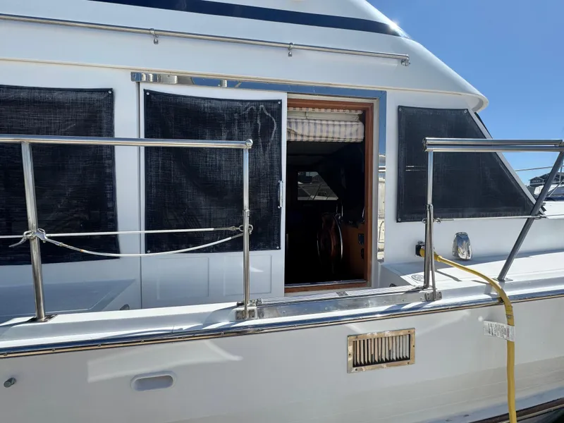Slide: The Image of 1990 Nova 48 yacht with open cabin door, stainless steel railings, and shaded windows. - 38