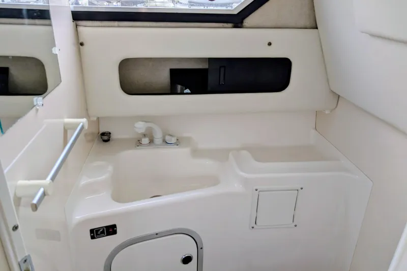 Slide: The Image of Interior of a 1997 Bayliner 2859 Ciera Express boat, featuring a compact sink area. - 25