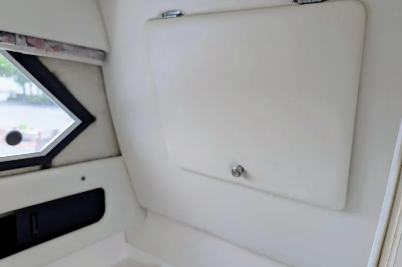 Slide: The Image of Interior of 1997 Bayliner 2859 Ciera Express, featuring a small window and storage compartment. - 27