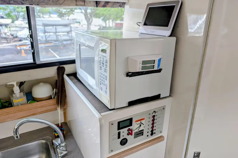 Slide: The Image of 1997 Bayliner 2859 Ciera Express kitchen with microwave, control panel, and sink. - 30