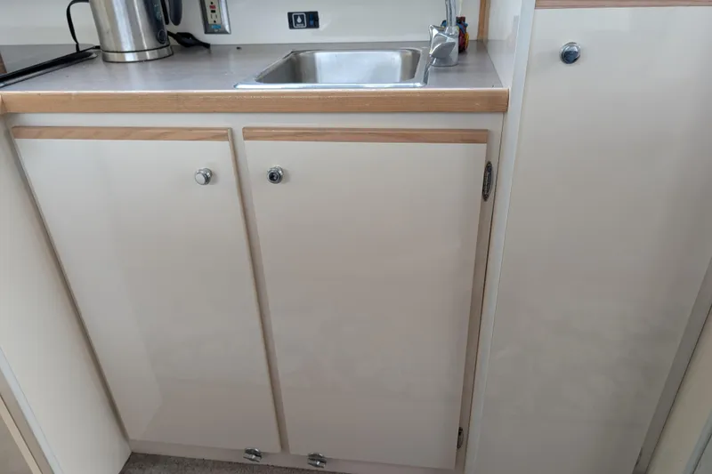 Slide: The Image of 1997 Bayliner 2859 Ciera Express kitchen area with sink and cabinets. - 32