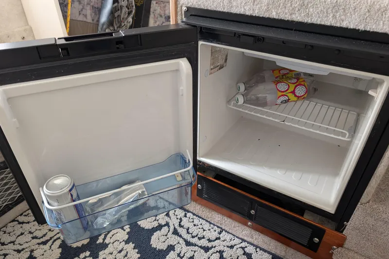 Slide: The Image of Open mini fridge inside 1997 Bayliner 2859 Ciera Express boat, containing drinks and snacks. - 43