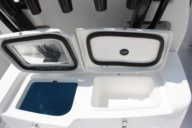 Slide: The Image of 2025 Tidewater 320 CC Adventure boat storage compartments with open lids. - 22