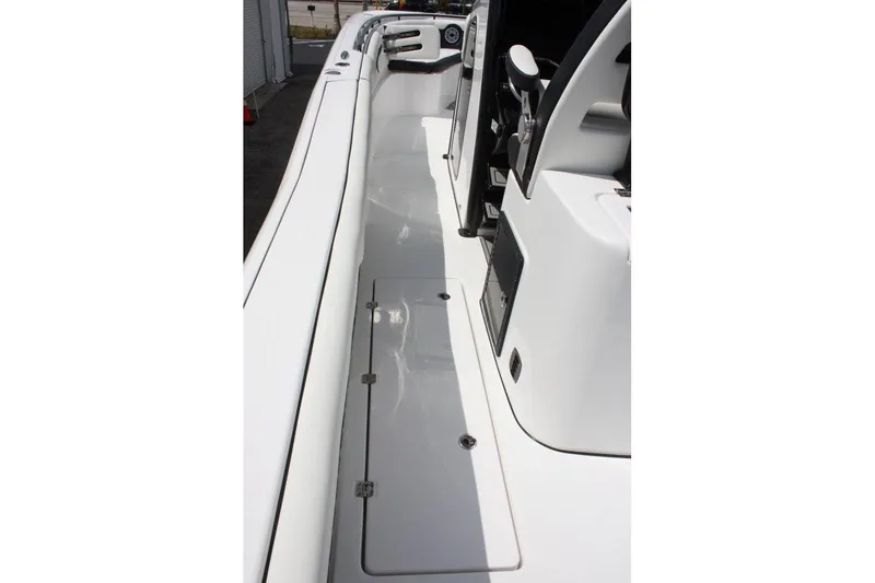 Slide: The Image of 2025 Tidewater 320 CC Adventure boat deck with sleek white finish and storage compartments. - 24