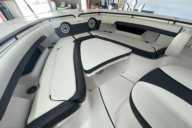 Slide: The Image of 2025 Tidewater 320 CC Adventure boat interior with cushioned seating and speakers. - 49