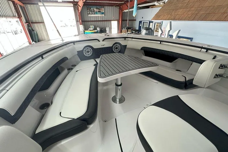 Slide: The Image of 2025 Tidewater 320 CC Adventure boat interior with seating and table in a marina setting. - 50