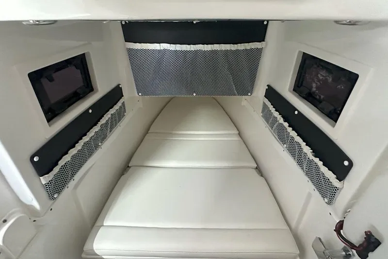 Slide: The Image of 2025 Tidewater 320 CC Adventure cabin interior with cushioned seating and storage nets. - 53