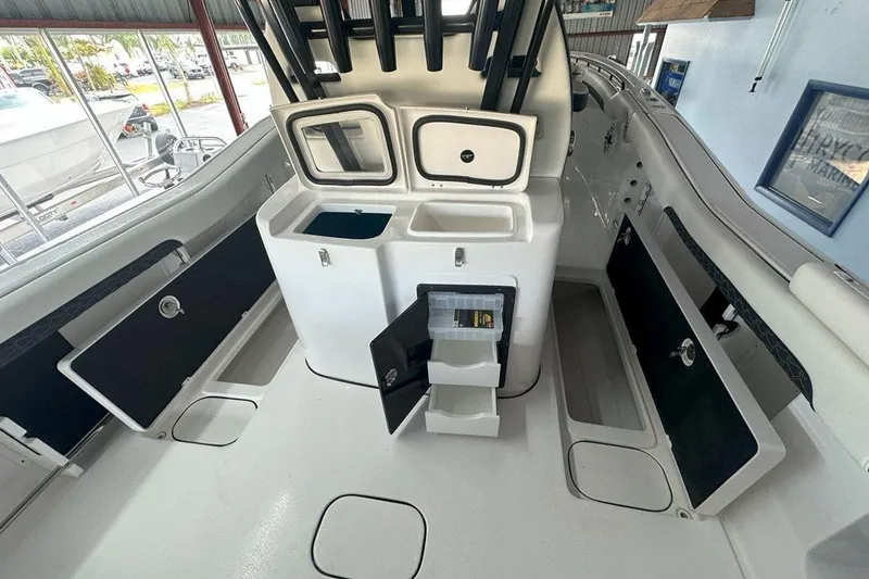 Slide: The Image of 2025 Tidewater 320 CC Adventure boat interior with storage compartments and fishing gear setup. - 57