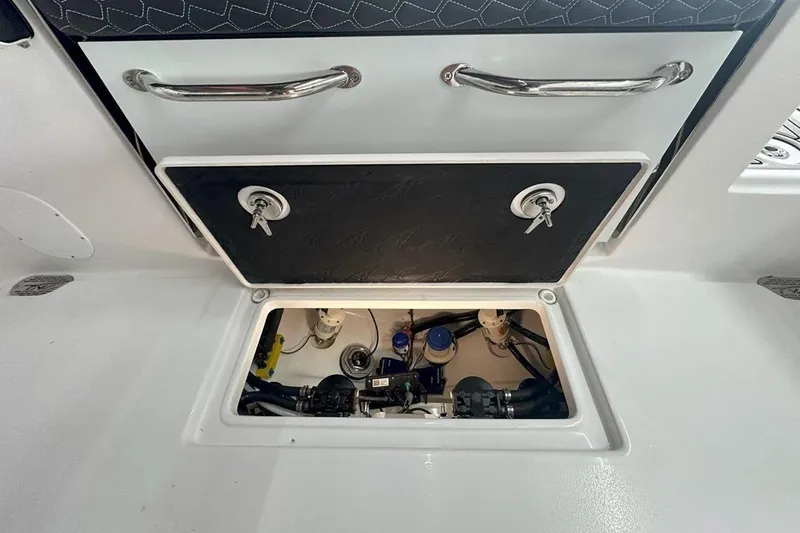 Slide: The Image of 2025 Tidewater 320 CC Adventure boat storage compartment with open hatch and visible equipment. - 59