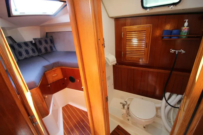 Slide: The Image of Interior of 1987 Hunter 34 sailboat showing cabin and bathroom with wooden finishes. - 17