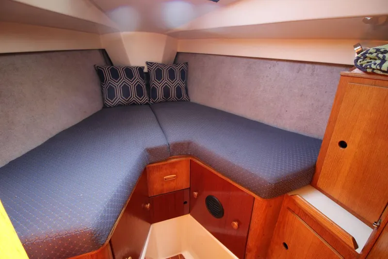 Slide: The Image of Cozy cabin interior of 1987 Hunter 34 sailboat with blue bedding and wooden storage. - 18