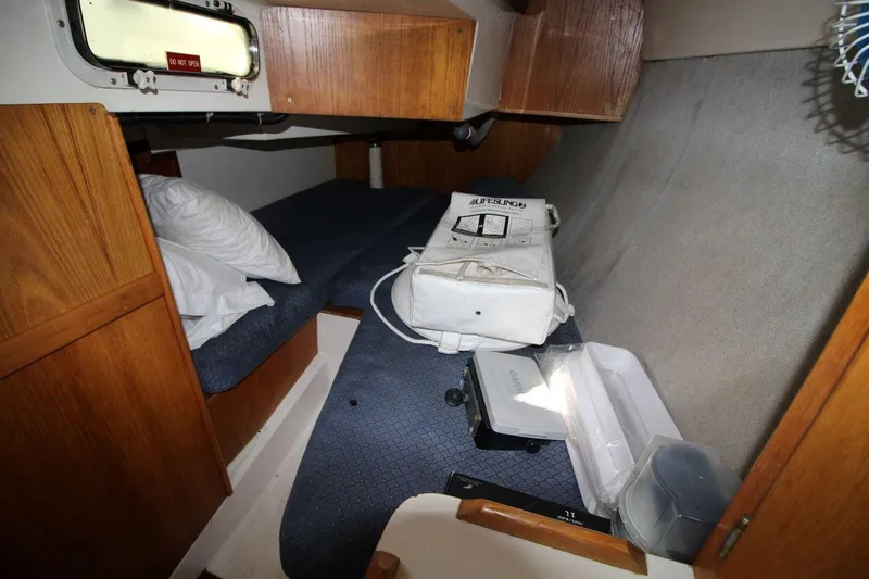 Slide: The Image of Interior cabin of a 1987 Hunter 34 sailboat with storage and bedding. - 21