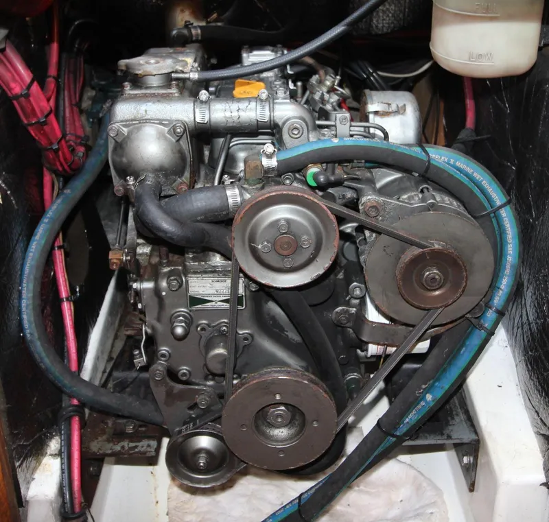 Slide: The Image of 1987 Hunter 34 engine with belts and hoses in a compact compartment. - 22