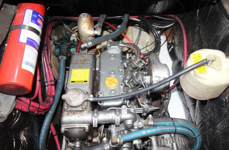 Slide: The Image of Engine compartment of a 1987 Hunter 34 sailboat, featuring wiring and a fire extinguisher. - 23