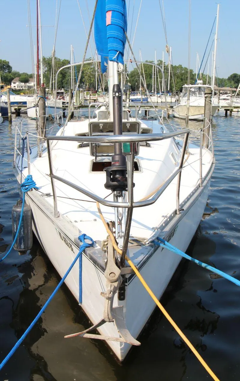 Slide: The Image of 1987 Hunter 34 sailboat docked in marina, front view with blue and yellow ropes. - 3