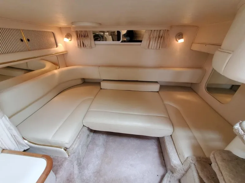 Slide: The Image of Interior of 2000 Sea Ray 310 Sundancer with beige seating and cozy lighting. - 10