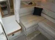 Slide: The Image of Interior of 2000 Sea Ray 310 Sundancer with white seating and a black cushion. - 13