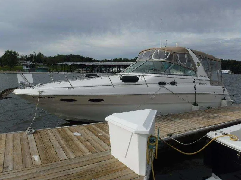 Slide: The Image of 2000 Sea Ray 310 Sundancer docked at a marina under cloudy skies. - 2