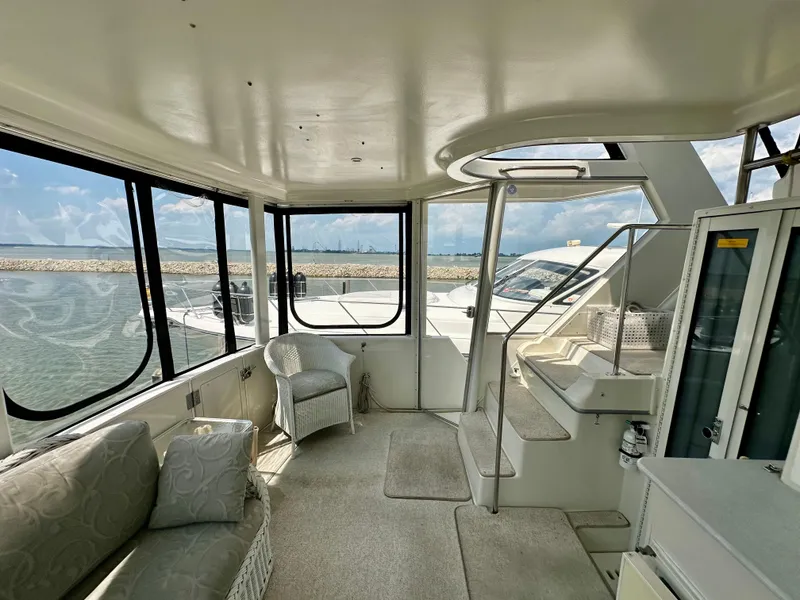 Slide: The Image of Interior of 1995 Carver 440 Aft Cabin Motor Yacht with wicker furniture and marina view. - 11